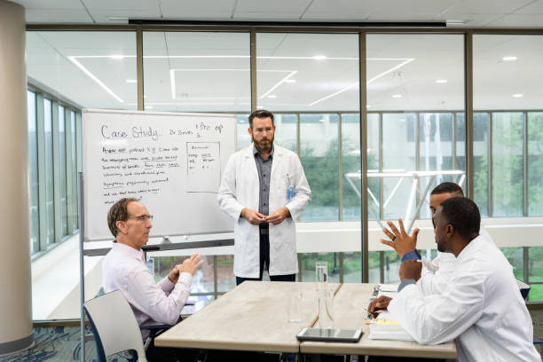 A group of healthcare professionals meet in a conference room to review an upcoming medical trial.