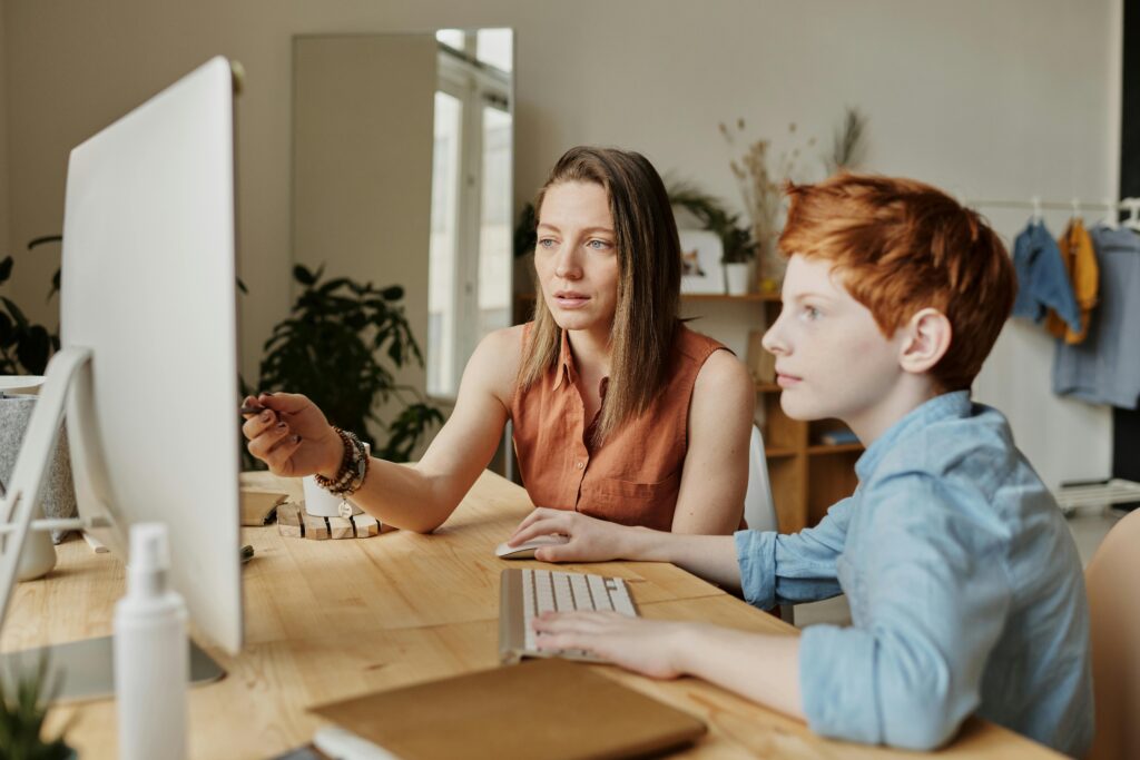 A woman tutoring a young boy.